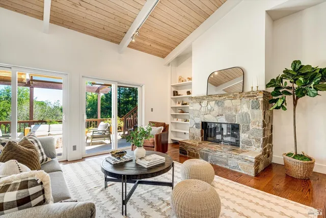 a living room with fireplace furniture and a large window
