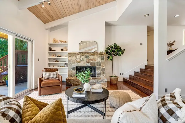 a living room with furniture fireplace and a large window