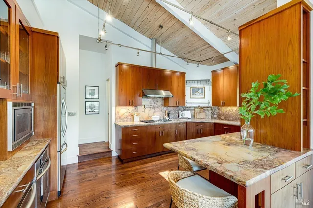 a kitchen with stainless steel appliances granite countertop a sink and wooden cabinets