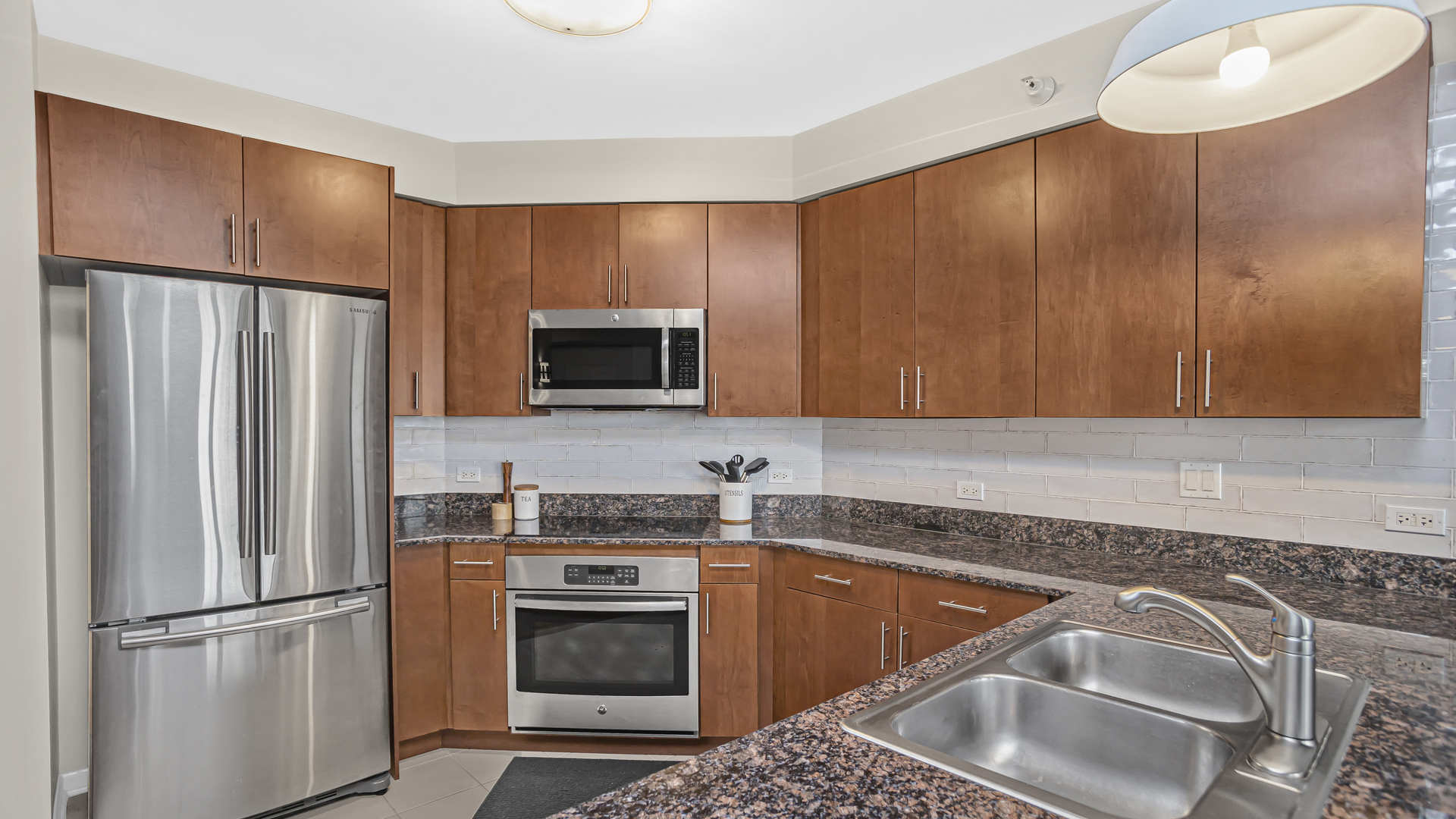 807 Davis Street, Unit 808 Evanston, IL 60201 - Photo 3 of 14 a kitchen with stainless steel appliances granite countertop a refrigerator stove and sink