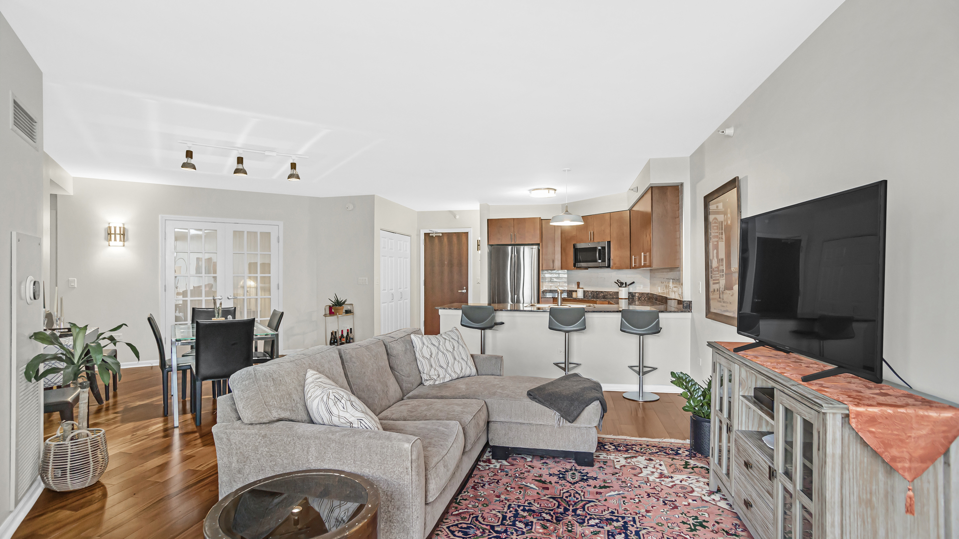 807 Davis Street, Unit 808 Evanston, IL 60201 - Photo 7 of 14 a living room with furniture a flat screen tv and kitchen view