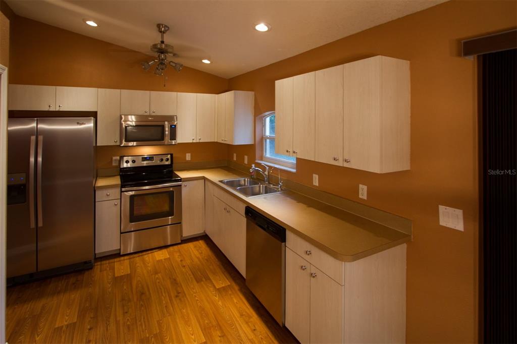 3092 Oklahoma Street North Port, FL 34286 - Photo 2 of 13 a kitchen with stainless steel appliances a refrigerator and a stove top oven