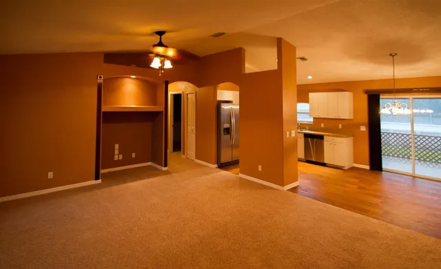 a view of an empty room with a fireplace and a chandelier