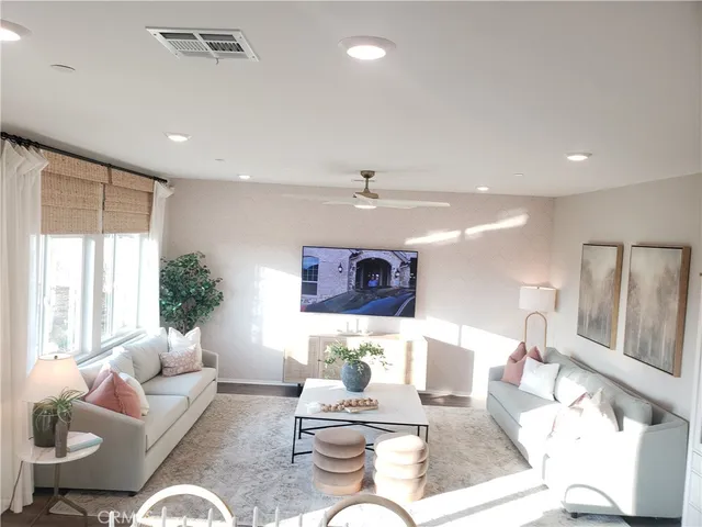 a living room with furniture potted plant and a large window