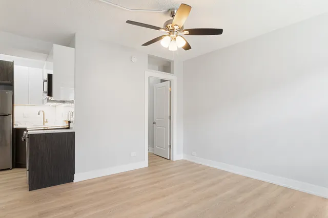 a view of a kitchen with a sink dishwasher a refrigerator with wooden floor