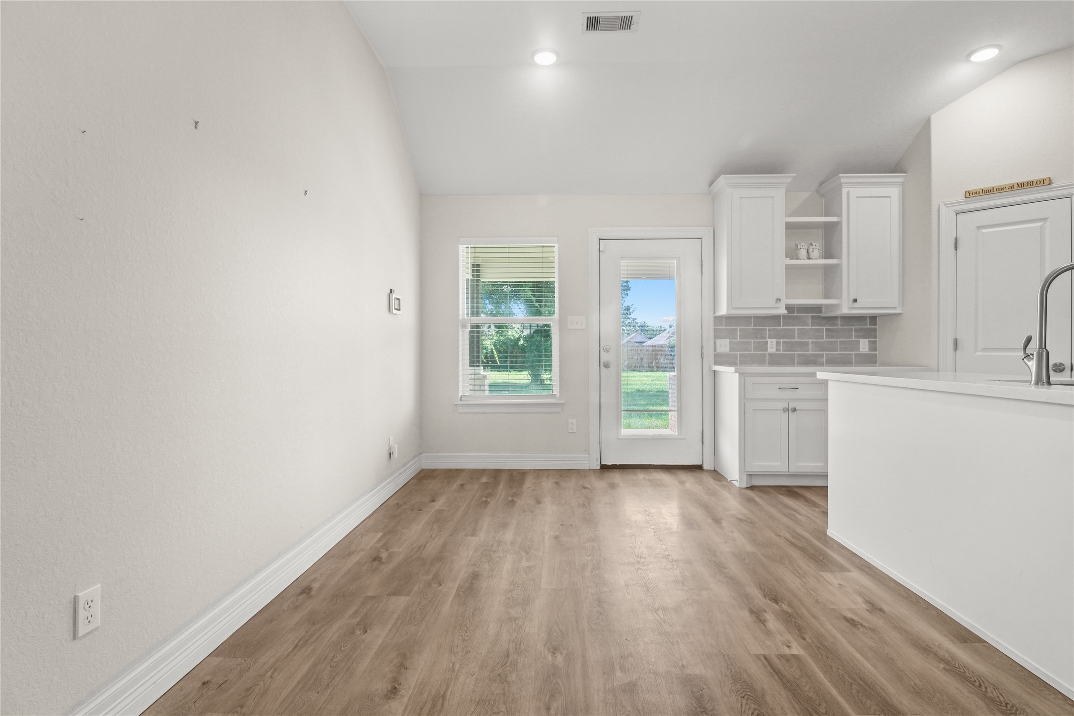 1208 East Henderson Road Angleton, TX 77515 - Photo 6 of 29 a view of a kitchen with wooden floor and a window