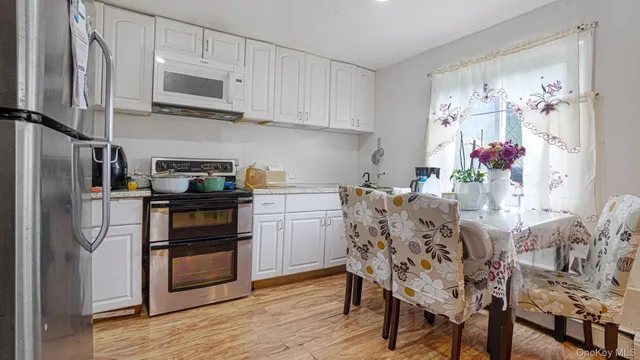 a kitchen with stainless steel appliances kitchen island granite countertop a refrigerator and microwave