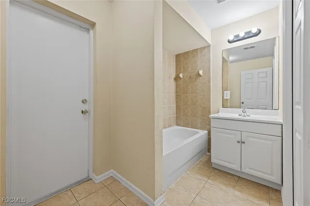 a bathroom with a tub sink shower and mirror