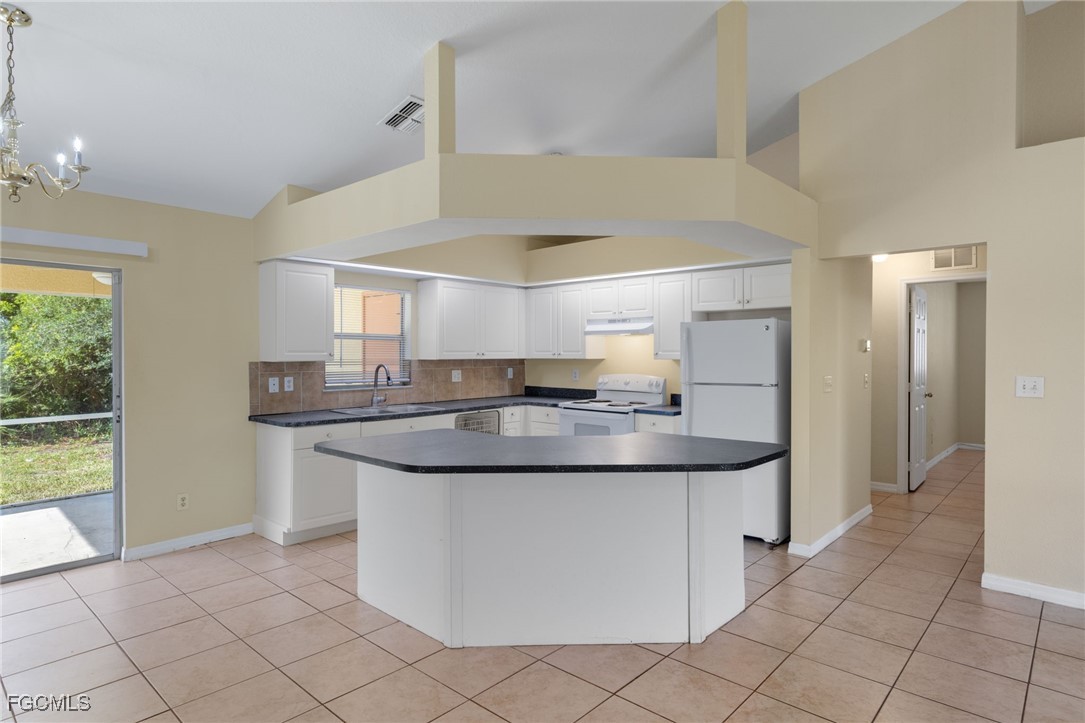 3733 16th Street West Lehigh Acres, FL 33971 - Photo 6 of 25 a kitchen with stainless steel appliances granite countertop a sink and a refrigerator