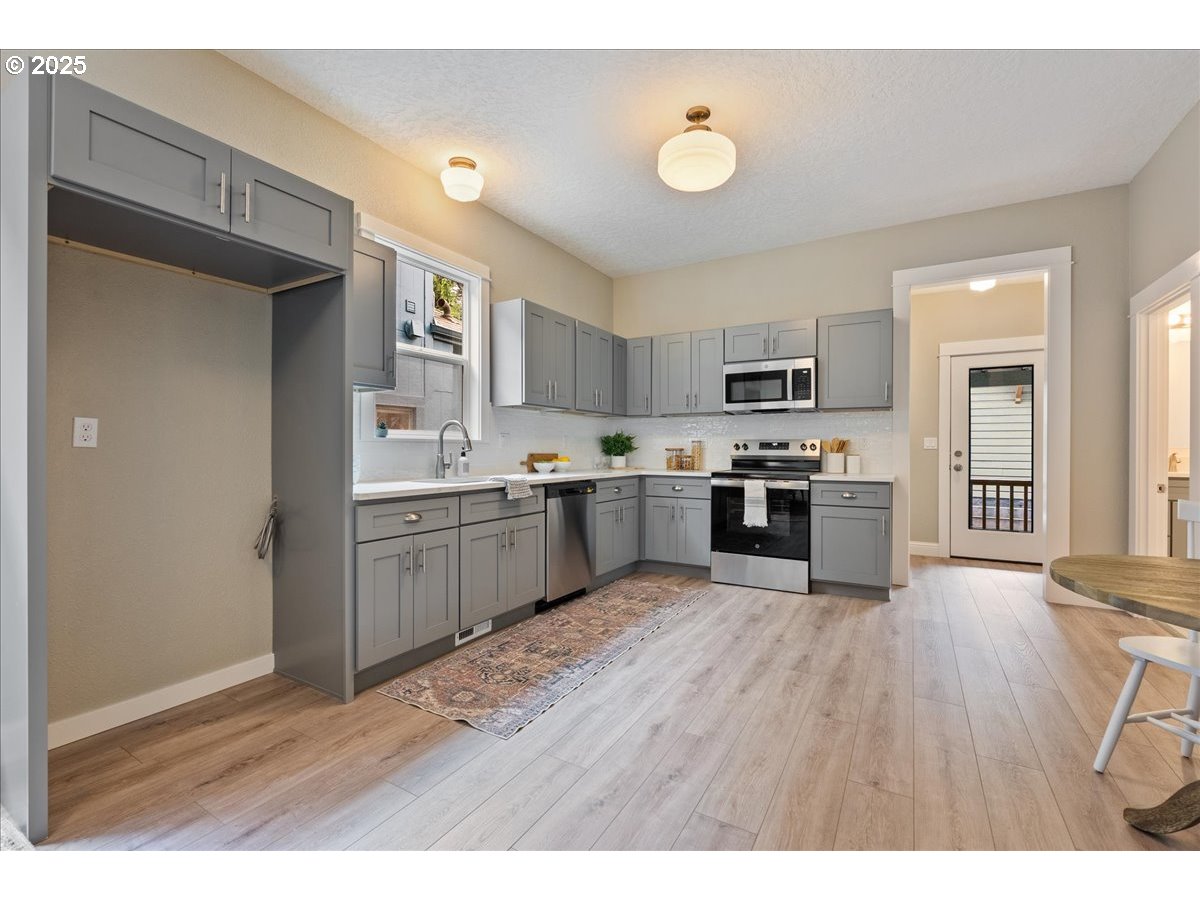 2115 Northwest 22nd Avenue Portland, OR 97210 - Photo 11 of 47 a kitchen with a sink cabinets stainless steel appliances and a window