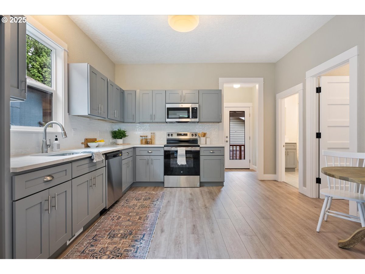 2115 Northwest 22nd Avenue Portland, OR 97210 - Photo 12 of 47 a kitchen with granite countertop stainless steel appliances and wooden cabinets
