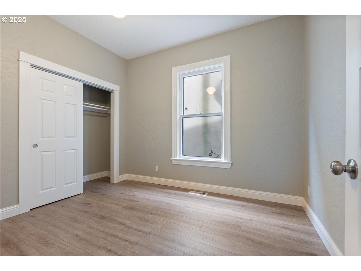 2115 Northwest 22nd Avenue Portland, OR 97210 - Photo 19 of 47 an empty room with wooden floor closet and windows