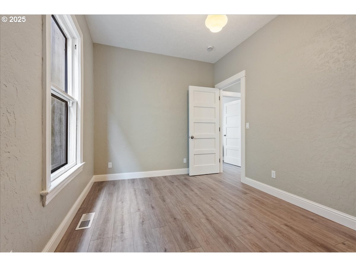 2115 Northwest 22nd Avenue Portland, OR 97210 - Photo 21 of 47 a view of an empty room with wooden floor and a window