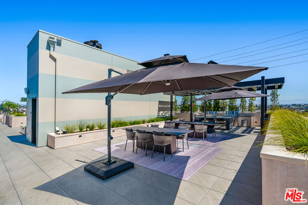 10700 Tabor Street, Unit 511 Los Angeles, CA 90034 - Photo 19 of 26 a view of the patio with a table and chairs under an umbrella