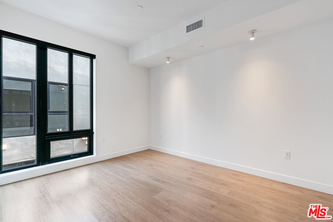 10700 Tabor Street, Unit 511 Los Angeles, CA 90034 - Photo 8 of 26 wooden floor in an empty room with a window