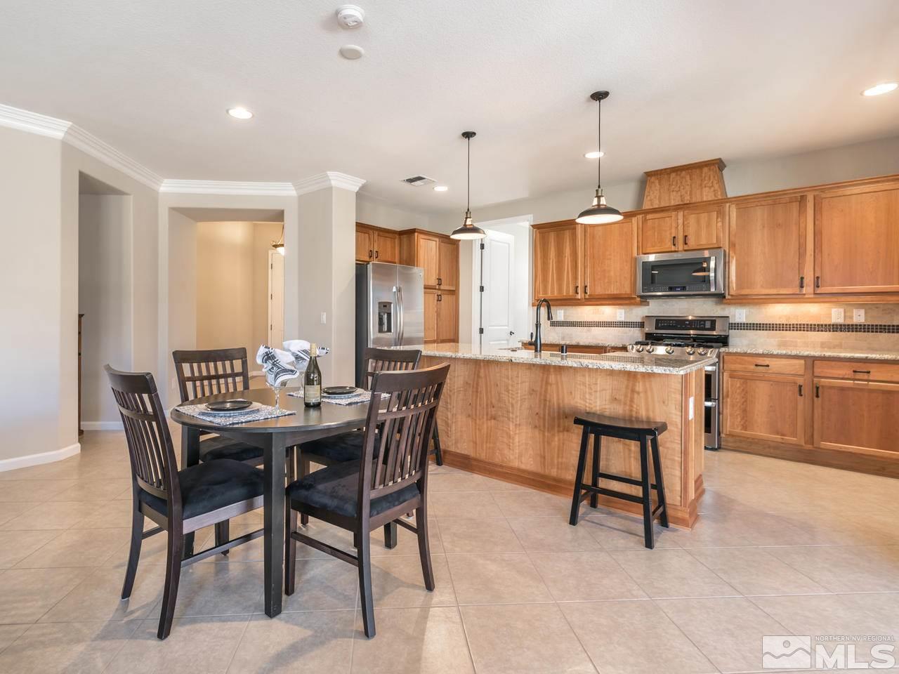 2180 Arpagos Lane Reno, NV 89521 - Photo 8 of 25 a kitchen with kitchen island a dining table and chairs
