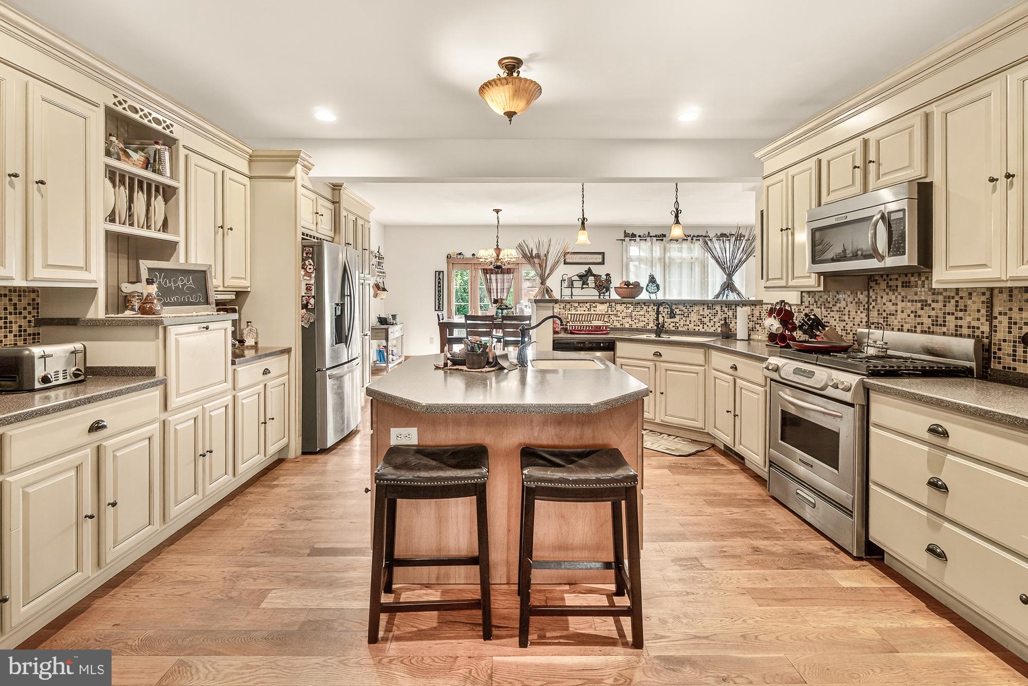 4948 Teen Barnes Road Frederick, MD 21703 - Photo 13 of 56 a kitchen with stainless steel appliances kitchen island granite countertop a sink and cabinets