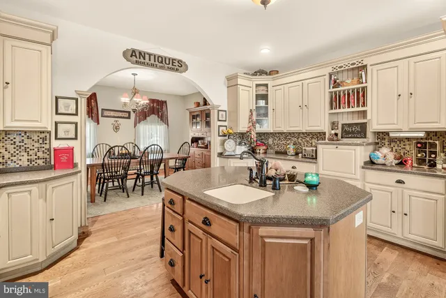 a kitchen with stainless steel appliances granite countertop a sink a stove and chairs