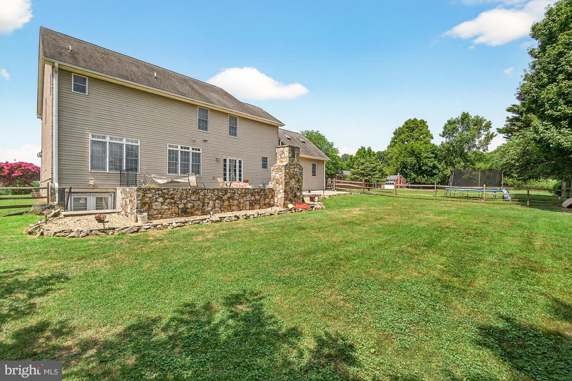 4948 Teen Barnes Road Frederick, MD 21703 - Photo 50 of 56 a backyard of a house with table and chairs plants and large tree