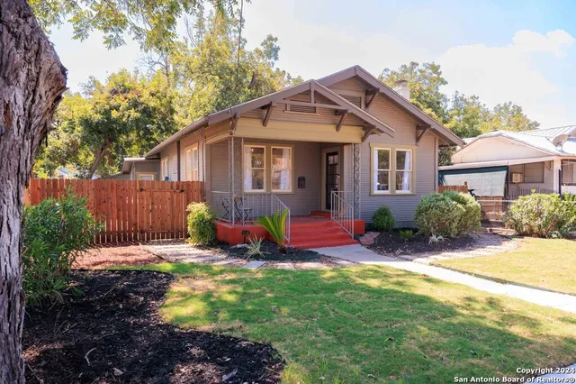 a view of a house with a yard patio and wooden fence
