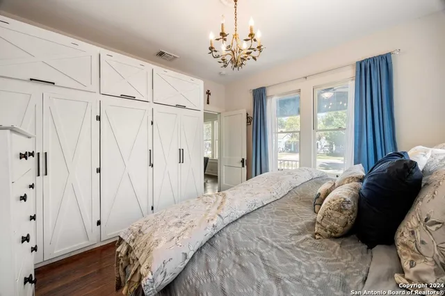 a bedroom with a large bed and a chandelier