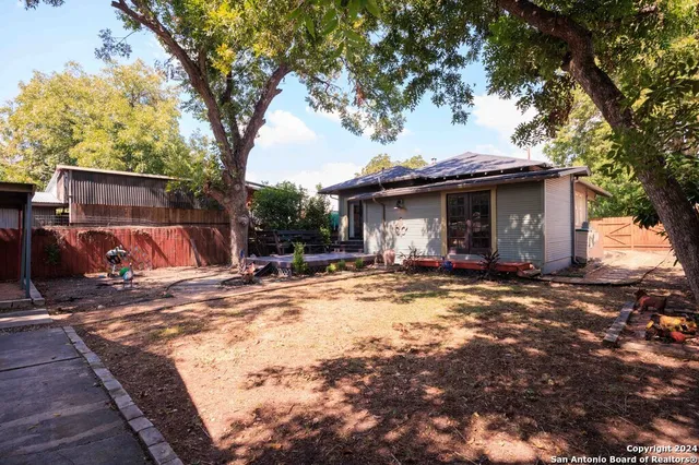 a view of a house with backyard and trees