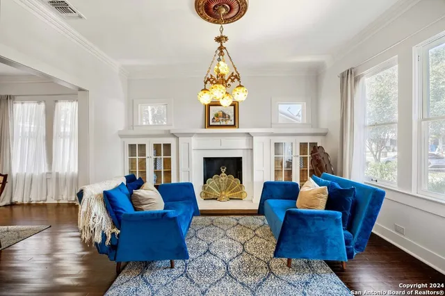 a living room with furniture a fireplace and a chandelier