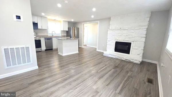 a view of kitchen with kitchen island wooden floor and electronic appliances
