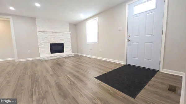 an empty room with wooden floor and fireplace