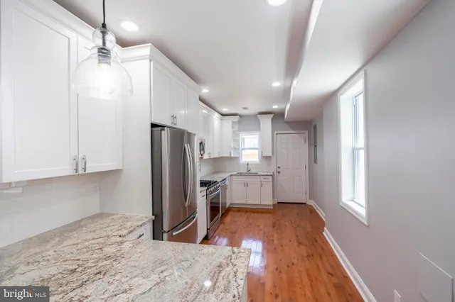 a kitchen with stainless steel appliances a refrigerator and a stove top oven