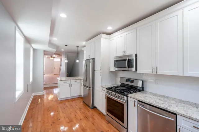 a kitchen with stainless steel appliances granite countertop a stove a sink and a refrigerator