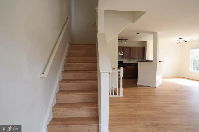 a view of entryway and kitchen with wooden floor