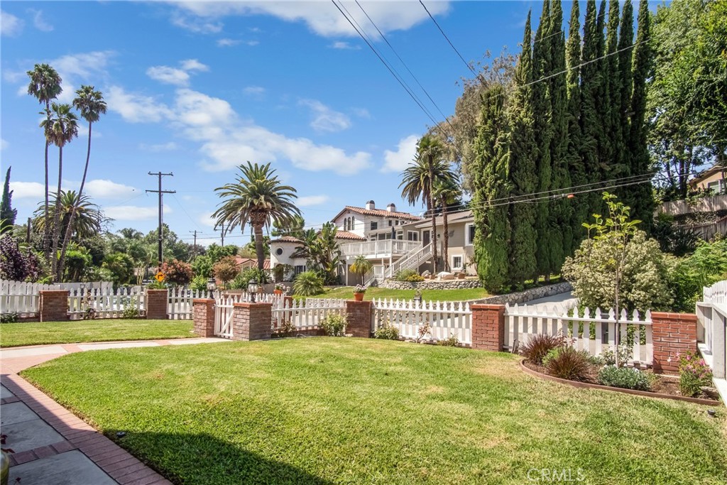 a view of a house with a yard and potted plants