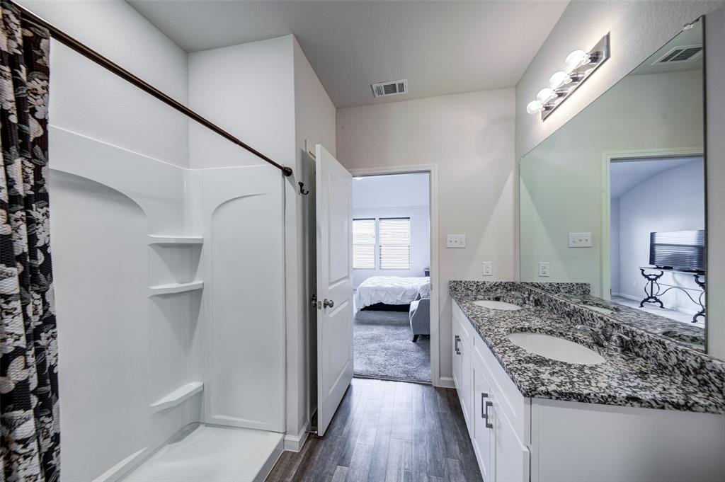 905 Avagail Avenue Springtown, TX 76082 - Photo 20 of 26 Bathroom featuring double vanity, ensuite bath, dark wood-type flooring, and curtained shower