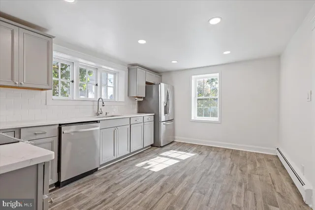 a kitchen with a sink wooden floor and white cabinets