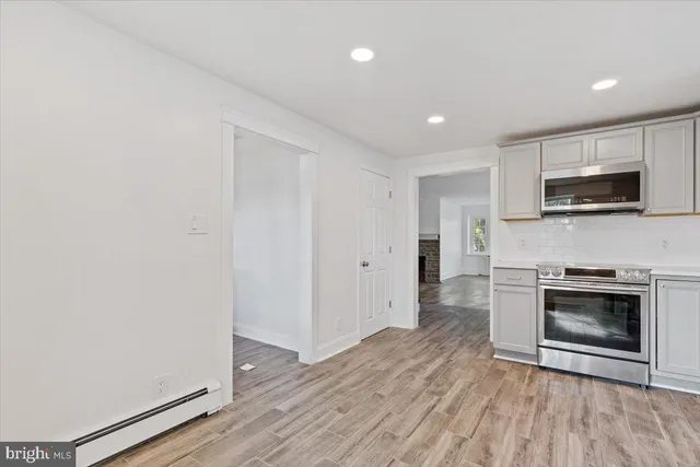 a view of a kitchen with a sink stove microwave and cabinets