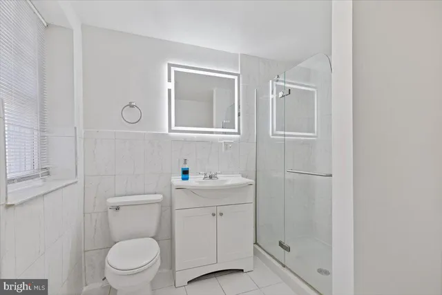 a bathroom with a toilet sink vanity and mirror
