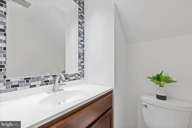 a bathroom with a sink a toilet and a mirror