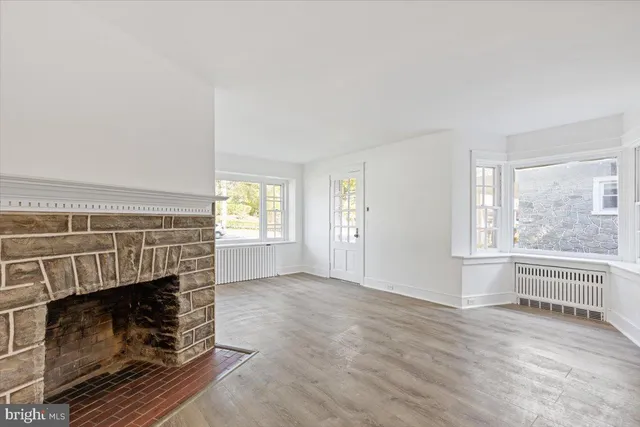 an empty room with fireplace and windows