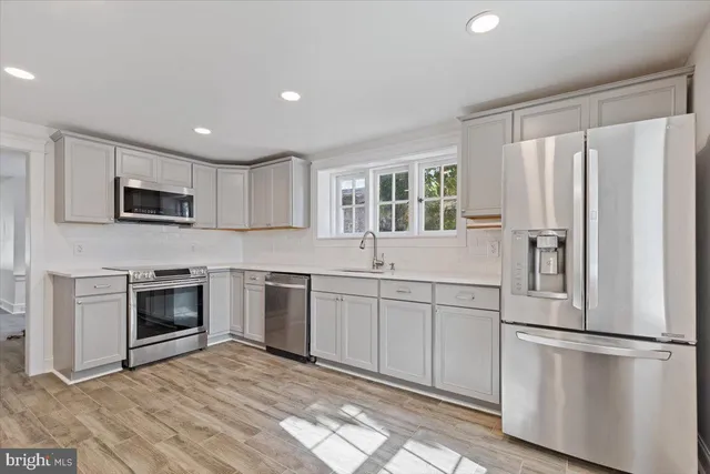 a kitchen with white cabinets and stainless steel appliances