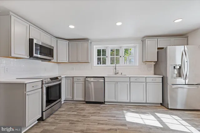 a kitchen with granite countertop a refrigerator and a stove top oven