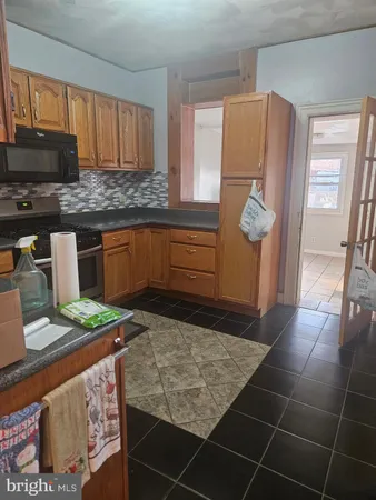 a kitchen with granite countertop a refrigerator and stove
