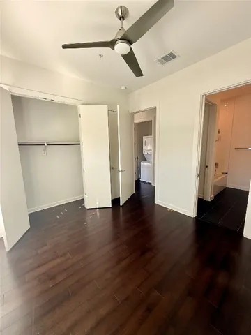 wooden floor in an empty room with kitchen view and kitchen view
