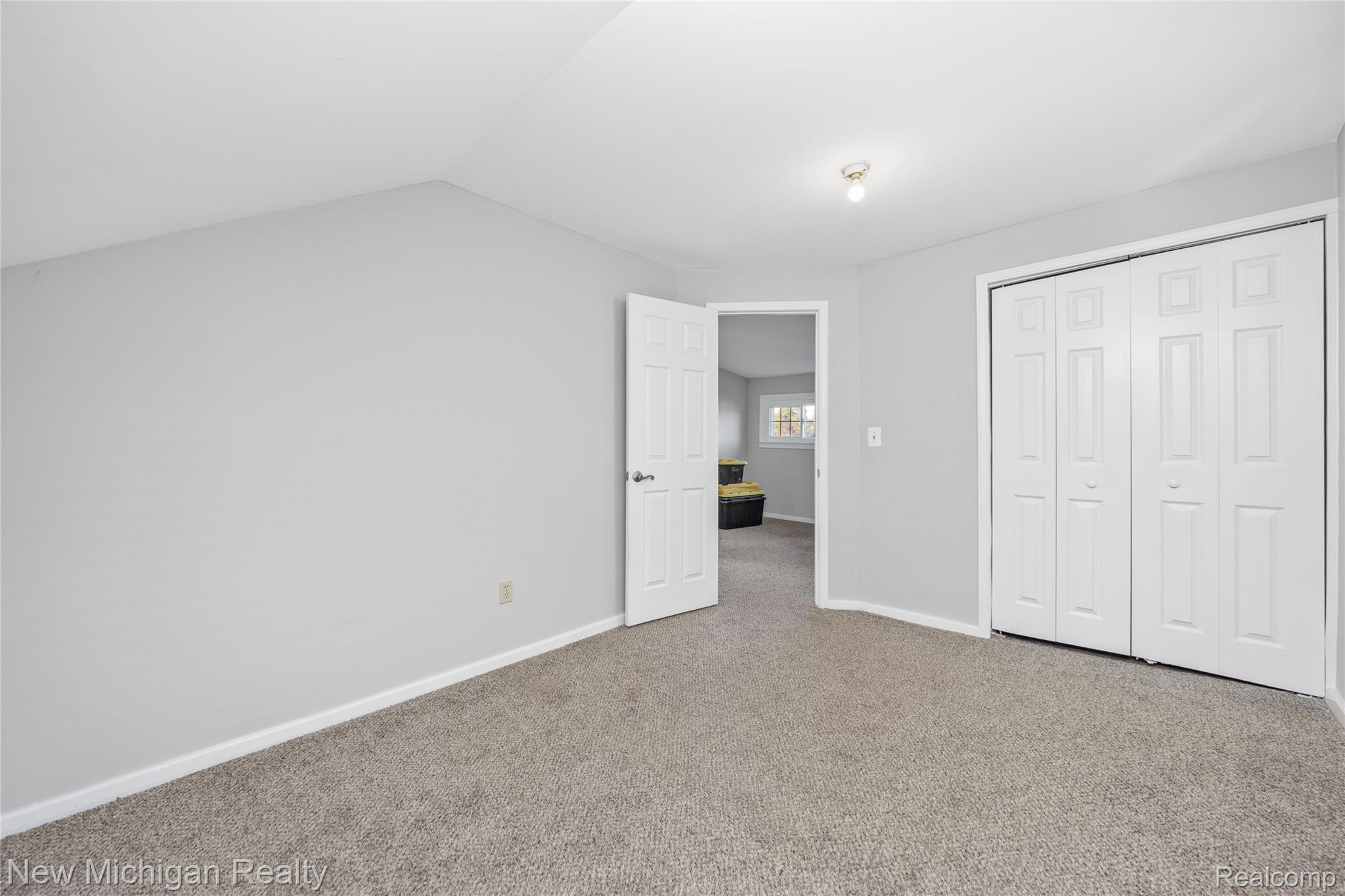 8665 Cooley Lake Road Commerce Township, MI 48382 - Photo 37 of 52 Unfurnished bedroom featuring carpet flooring, a closet, and vaulted ceiling