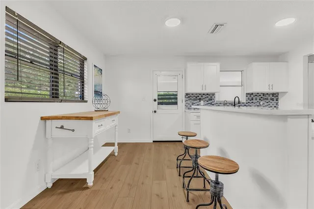 a kitchen with stainless steel appliances kitchen island a refrigerator and a stove top oven with white cabinets