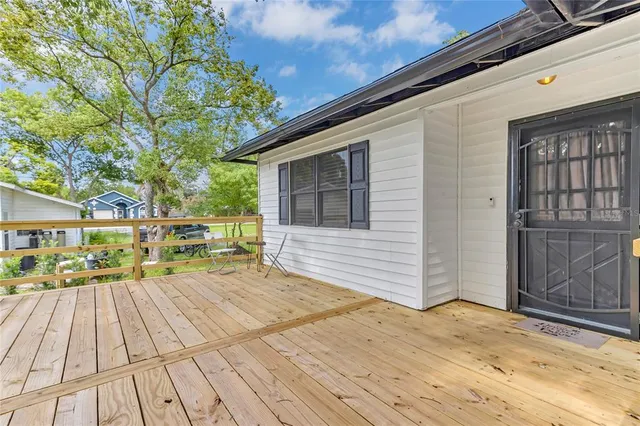 a view of a house with wooden deck and furniture