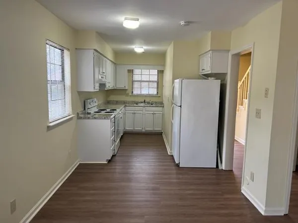 a kitchen with a refrigerator a sink and cabinets