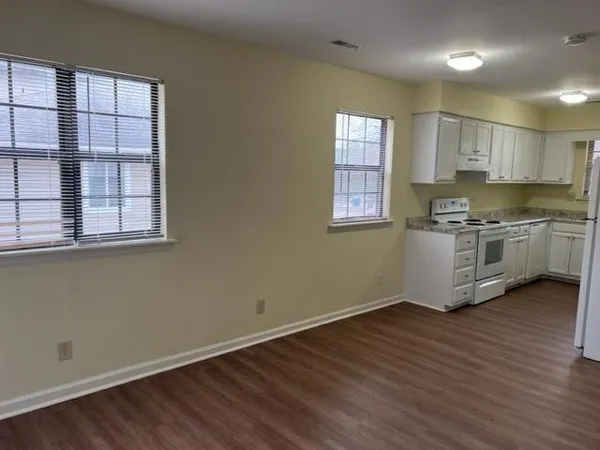 an empty room with wooden floor and window
