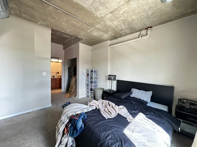 a bedroom with a bed a couch and a night stand