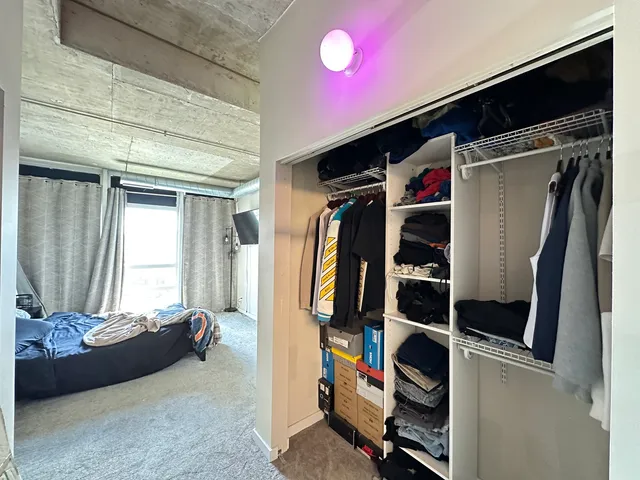 a view of walk in closet with clothes and shoes